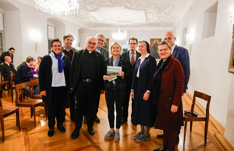 Sonntagsblatt/Gerd Neuhold, Gerd Neuhold Verteidigungsministerin Klaudia Tanner mit der letzten Ausgabe der 'Offensive' der Katholischen Aktion zum Thema 'Frieden', und Bischof Wilhelm Krautwaschl, umringt von Vertreter:innen der einzelnen Kurien des KLRÖ